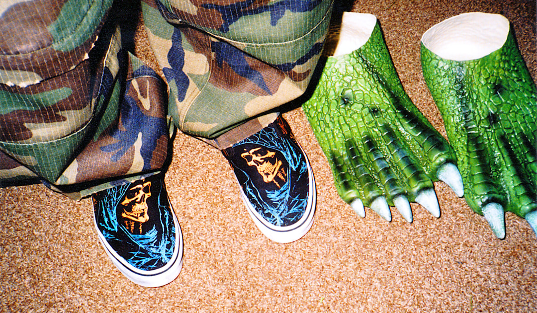 Overhead image of someone wearingVans classic slip ons standing next to a pair of slip on monster costume feet.
