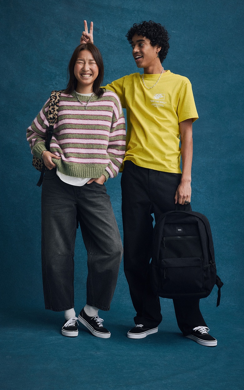 A group of boys and girls smile at the camera together wearing Vans shoes and clothes.