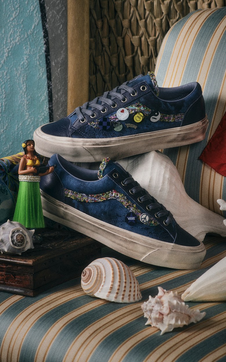 A pair of navy blue Souvenir Old Skool on a chair next to sea shells and a luau bobblehead.