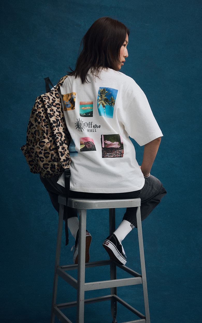 A young woman poses in a photography studio wearing new Vans shoes, clothes, and a backpack for Back to School.