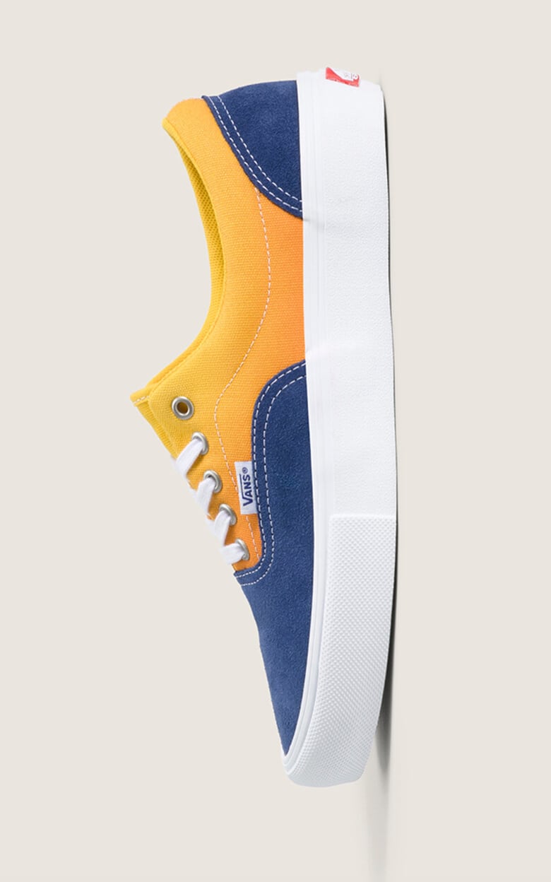 Medium shot set in a gray photography studio of a single vertical Skate Era shoe in Gradient Navy Blue / Yellow.