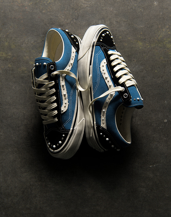 An overhead shot of the black and navy Premium Old Skool 36 Pearlized colorway on a concrete floor.