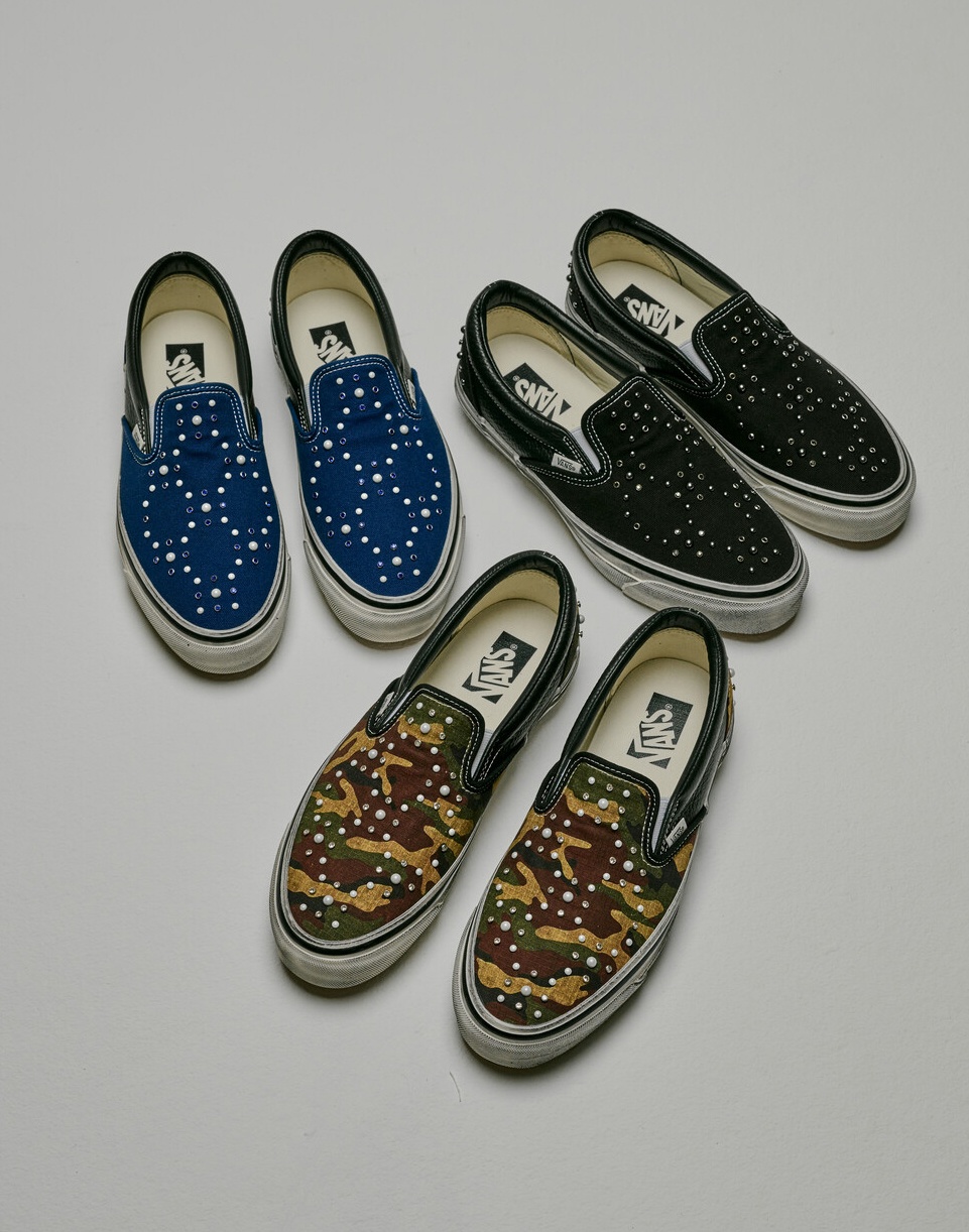 An overhead shot of three Premium Classic Slip-On shoes, including blue, black, and camo colorways.