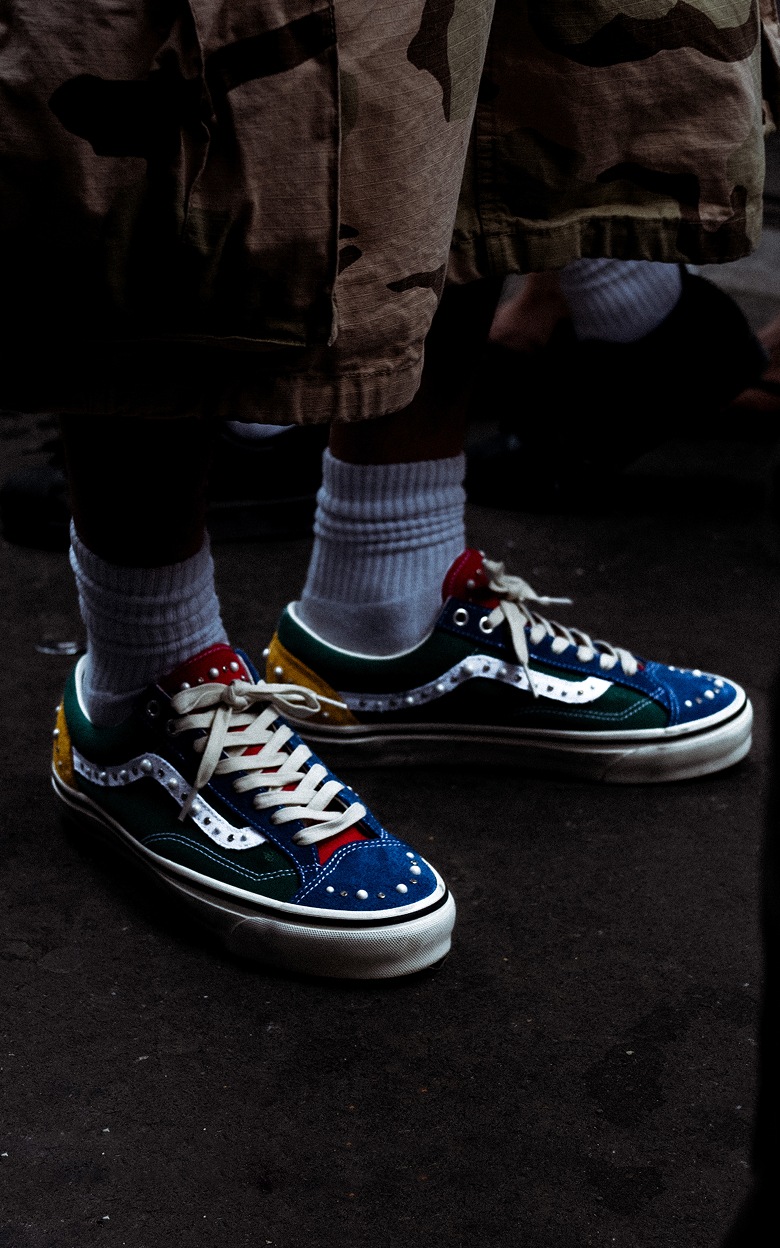 Medium knee down shot of the Pearlized Premium Old Skool 36 in the Yacht Club colorway in a dark studio.