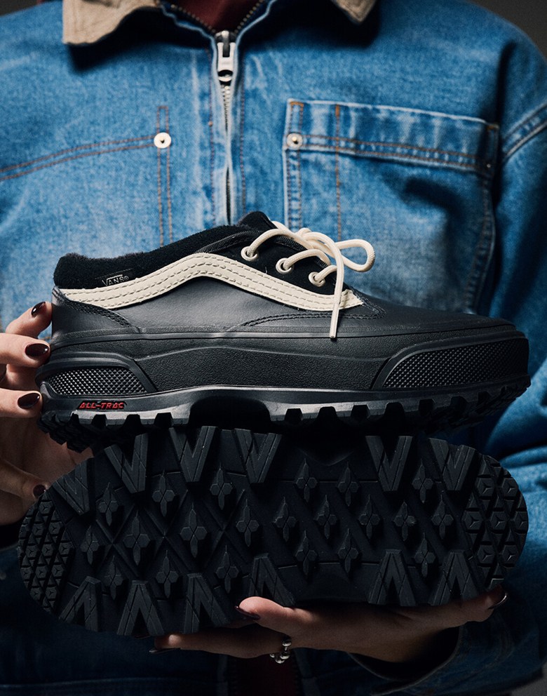 Medium shot of someone holding the Standard Low in black with the shoe in high focus, and their jean jacket blurred in the background.