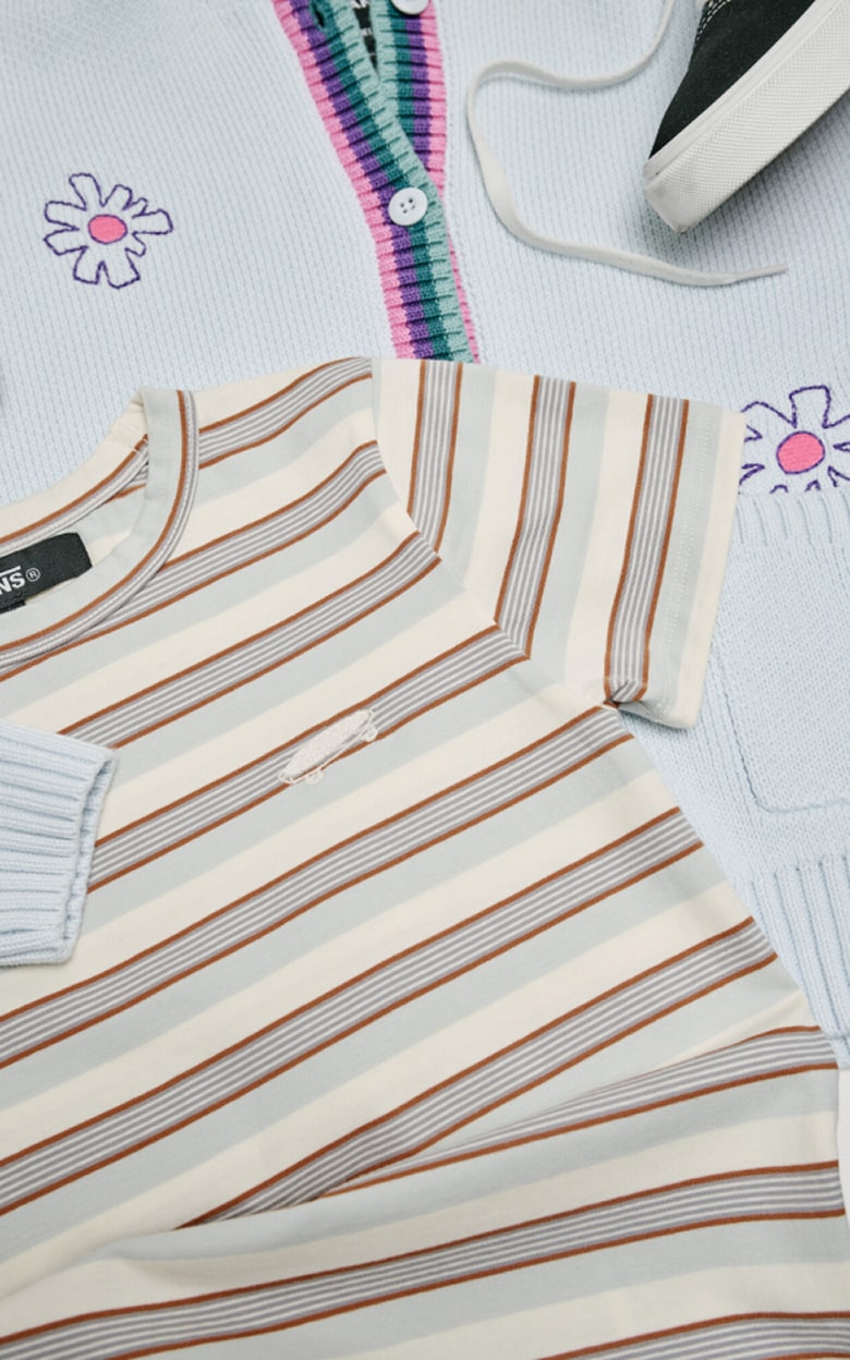 Flat lay top down shot of the Fiona Floral Sweater, Lucie Striped Knit Top, Kids Old Skool Shoe with a removable chain, and the Davey Workwear Overall