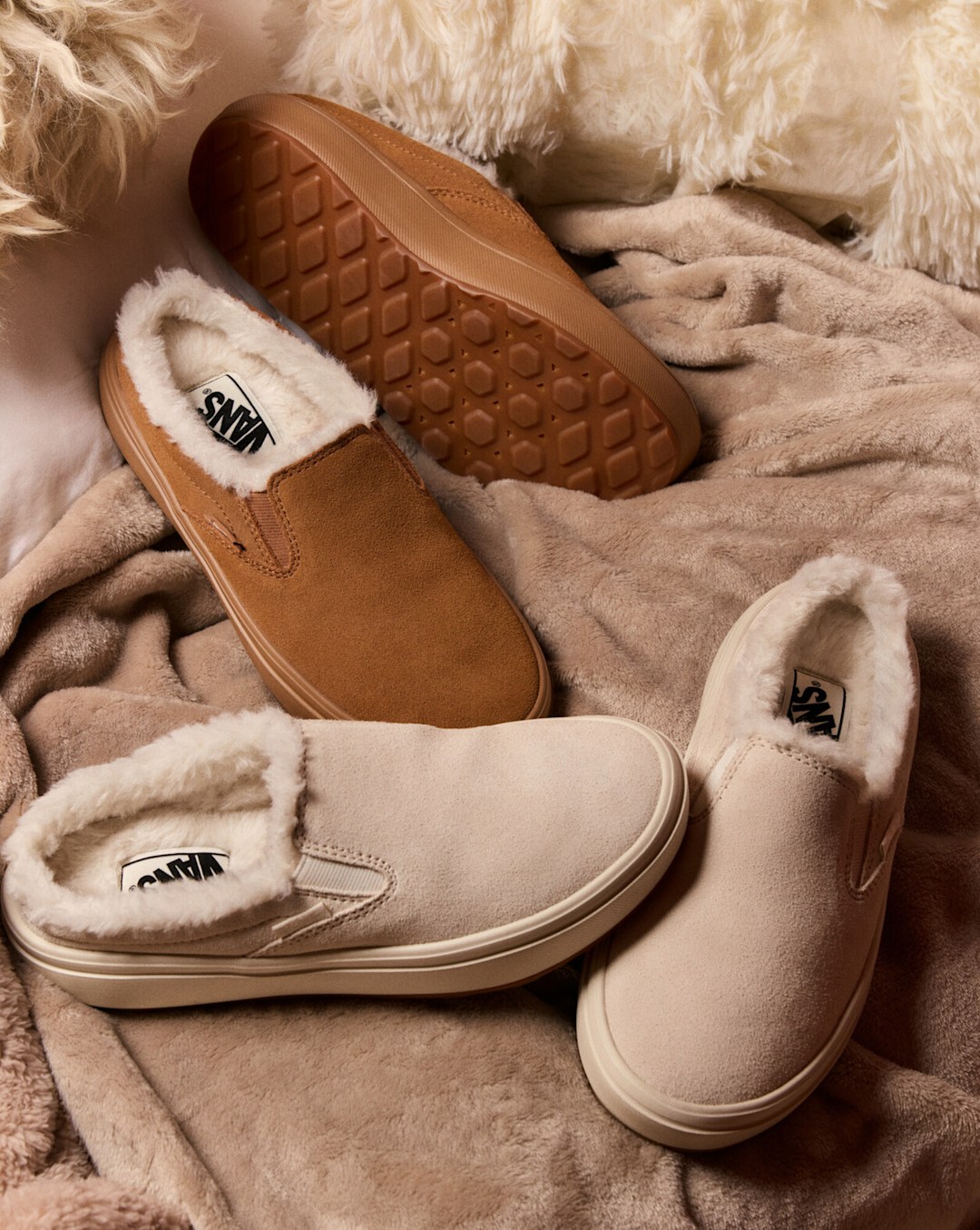 Cozy Vans slip-on shoes with soft fleece lining displayed on blankets and faux fur with the text "Cozy."