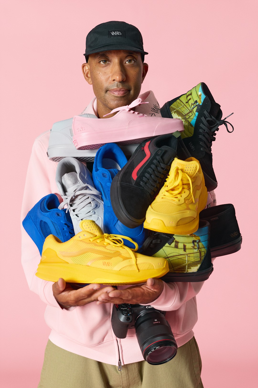 Atiba Jefferson holding United Through Skateboarding Vans shoe assortment.