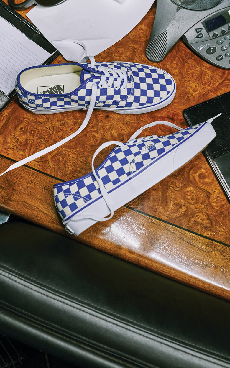 An overhead shot of the blue and white Checkerboard Authentic from the Vans, MLB, and Los Angeles Dodgers collection on a desk.