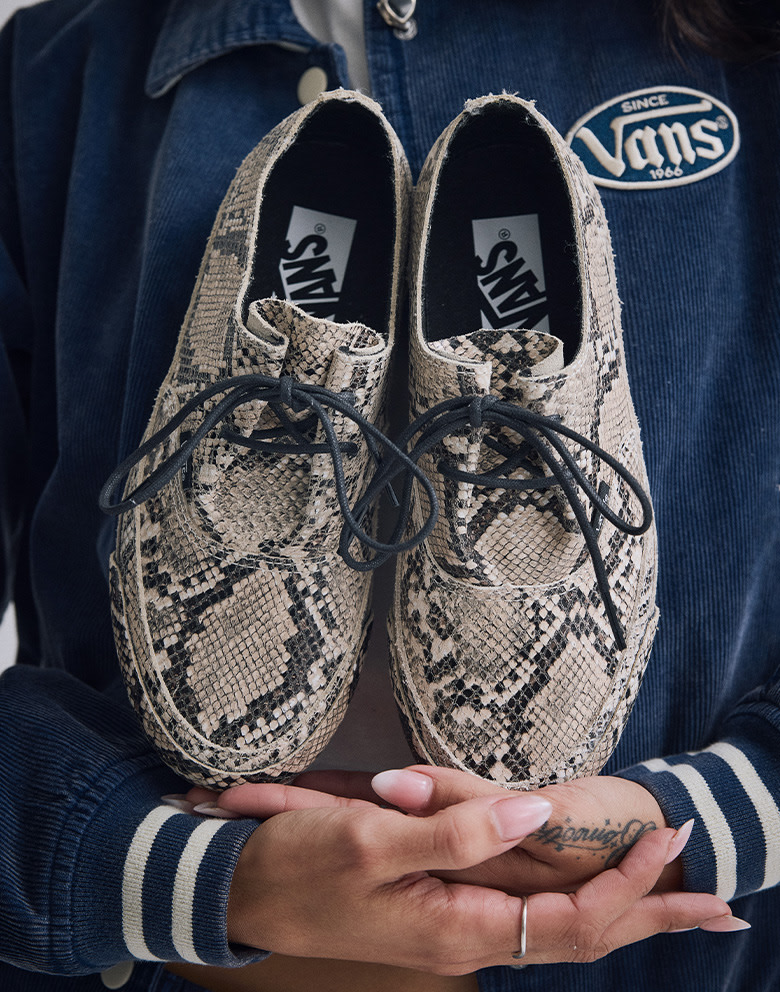 Close-up on someone holding a pair of white and black crocodile skin Authentic.
