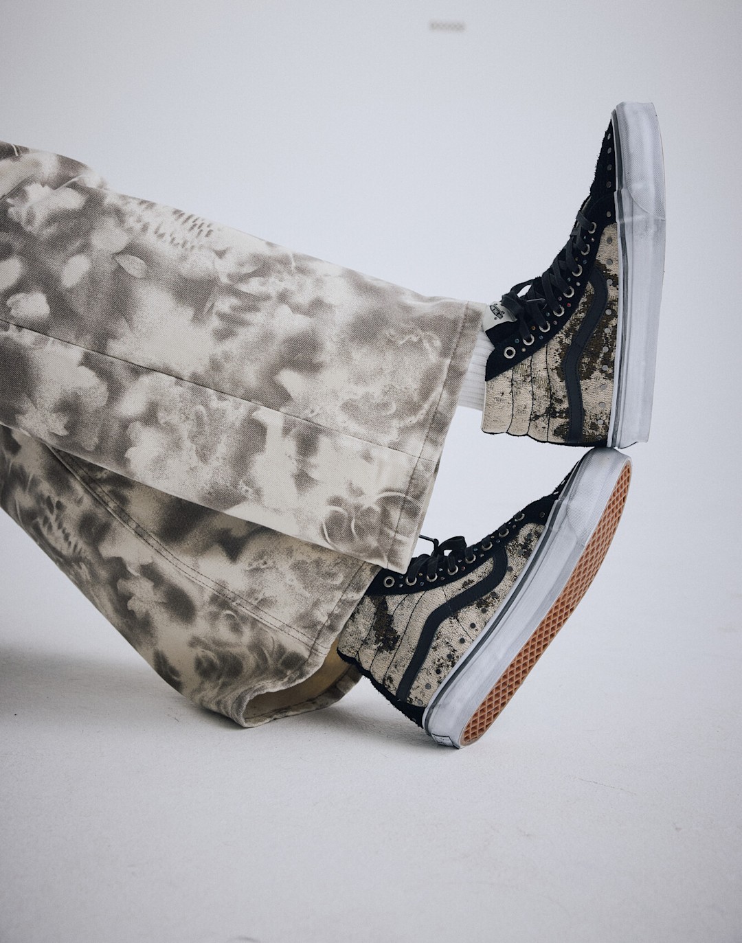Photo prise au niveau du genou d'une personne portant une paire de Vans Sk8-Hi.