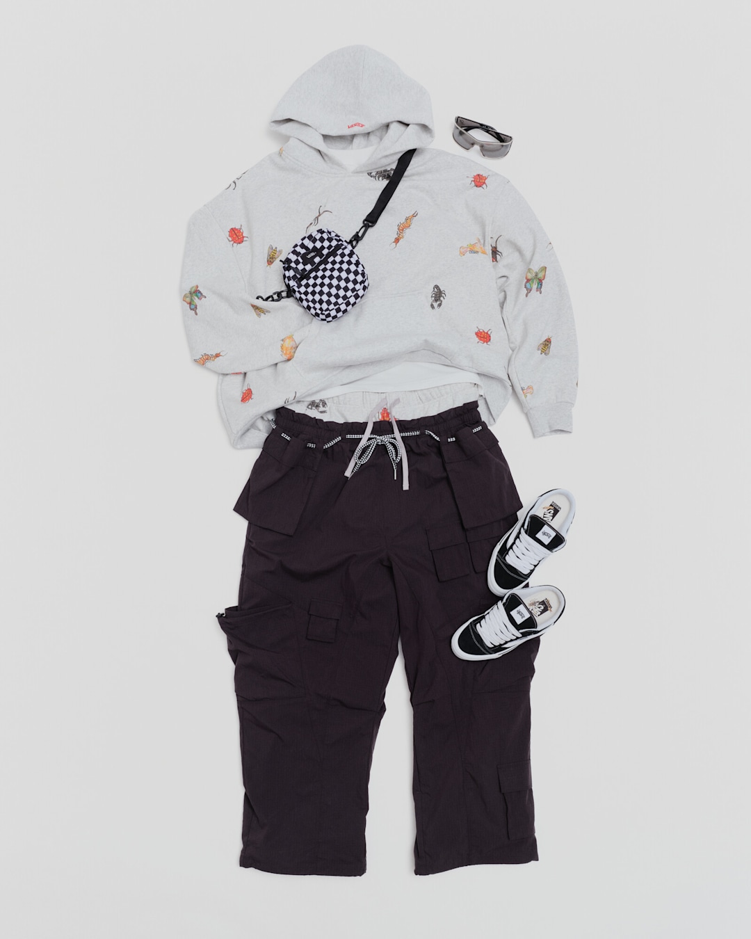 Curated Vansza outfit featuring a graphic Bugout Hoodie, Parachute Pant, checkered Bail Shoulder Bag, and Knu Skool Mule.
