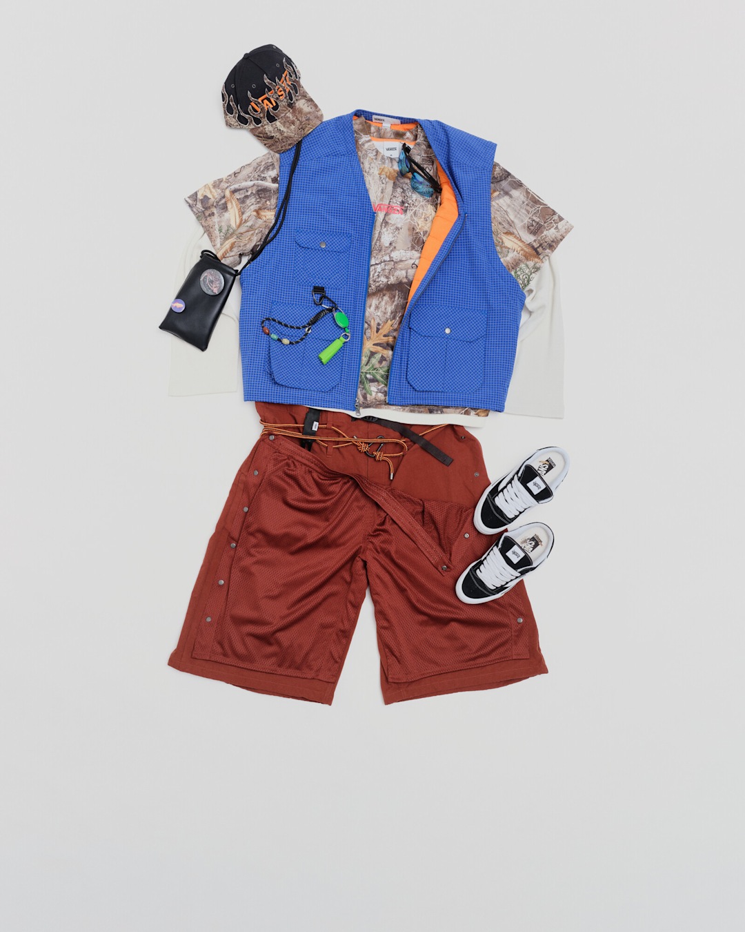 VANSZA outfit flat lay featuring the Snapback Hat, Hunting Vest, Layer Long Sleeve Top, Outdoor Oversized Short, and Knu Skool Mule.