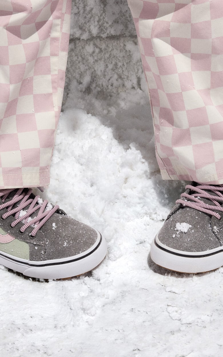Close-up on a kid wearing pink and green Old Skool Weatherized Insulated Shoes in the snow.