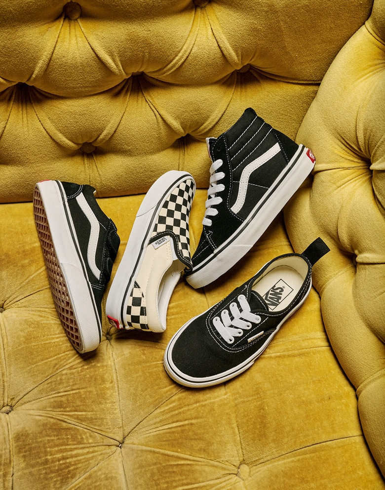 An overhead shot of Kids’ black and white Icons, including the Authentic, Old Skool, Sk8-Hi, and Checkerboard Classic Slip-On.