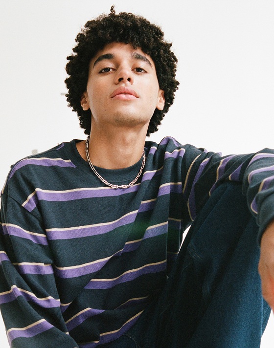 A young man wearing a Parisian night blue Vorlop Stripe Long Sleeve Knit shirt.