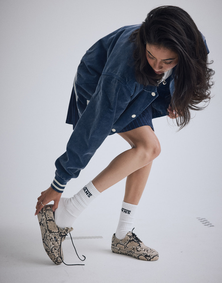 A young woman bends over checking the fit of her Python Turtledove White Premium Authentic Ease Shoes.