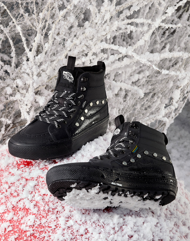 A pair of black and silver-studded Sk8-Hi GORE-TEX Insulated Shoes lie in the snow.