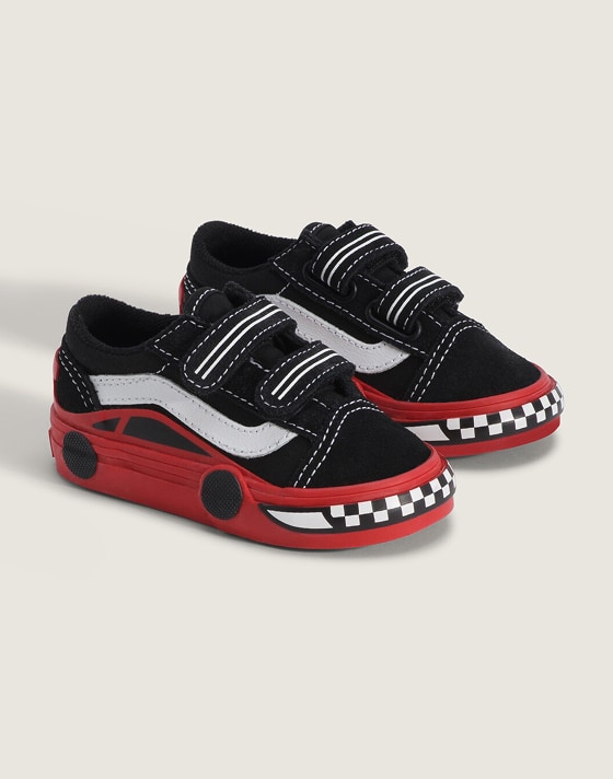 A pair of red and black race car Toddler Old Skool V Shoe in a photo studio.