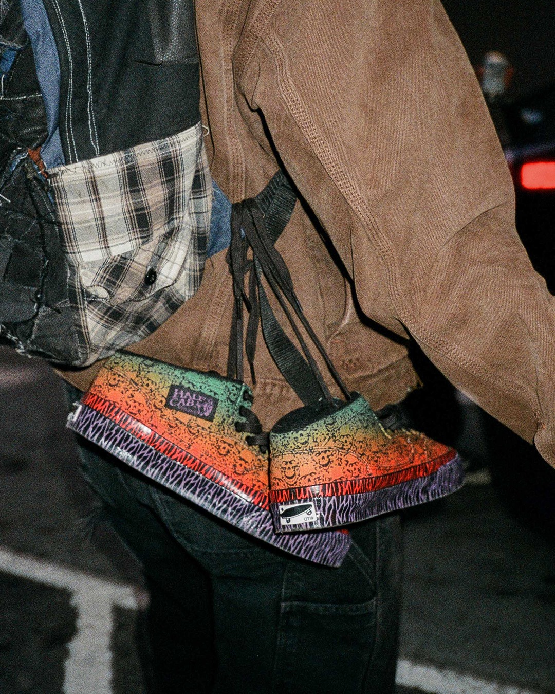 A pair of OTW x Bad Idea by CHITO Half Cab 33 handing on the shoulder strap of a backpack. 