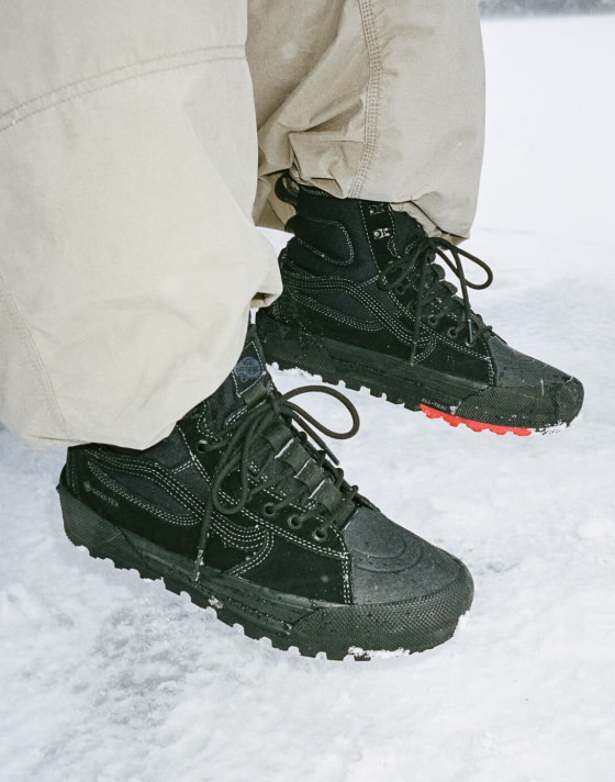 A close-up of a pair black MTE Sk8-Hi shoes hanging off a truck bed over some snow.