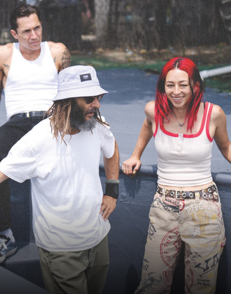 A group of skaters and BMX riders take a break at a skate park.