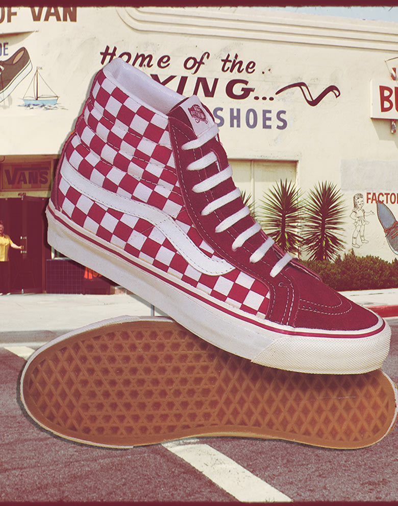 A pair of red checkerboard Sk8-Hi superimposed in front of a photograph of the old Vans store.