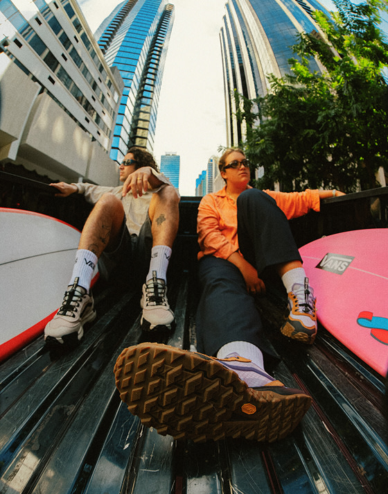 Two people sitting in a truck bed while looking at the city landscape while wearing MTE Crosspath XC shoes.