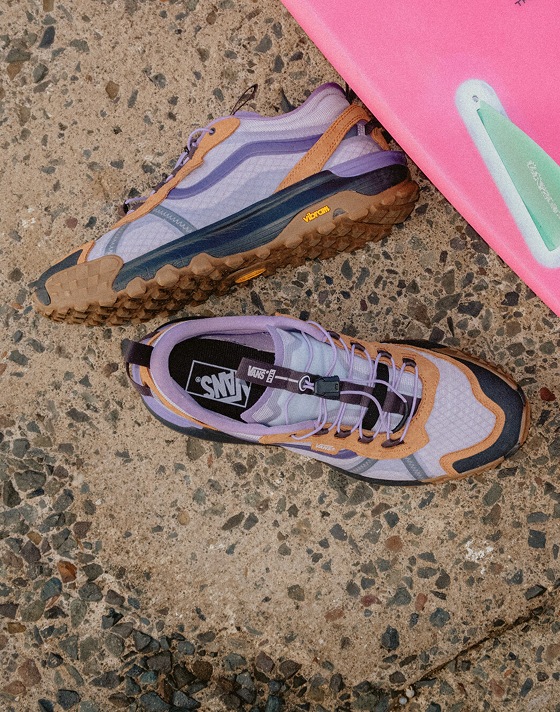 A close-up of purple and orange MTE Crosspath XC shoes on a rocky surface.