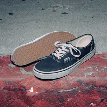 A pair of Authentic shoes placed on a red textured curb. The waffle patterned sole can be shown in the shot. 
