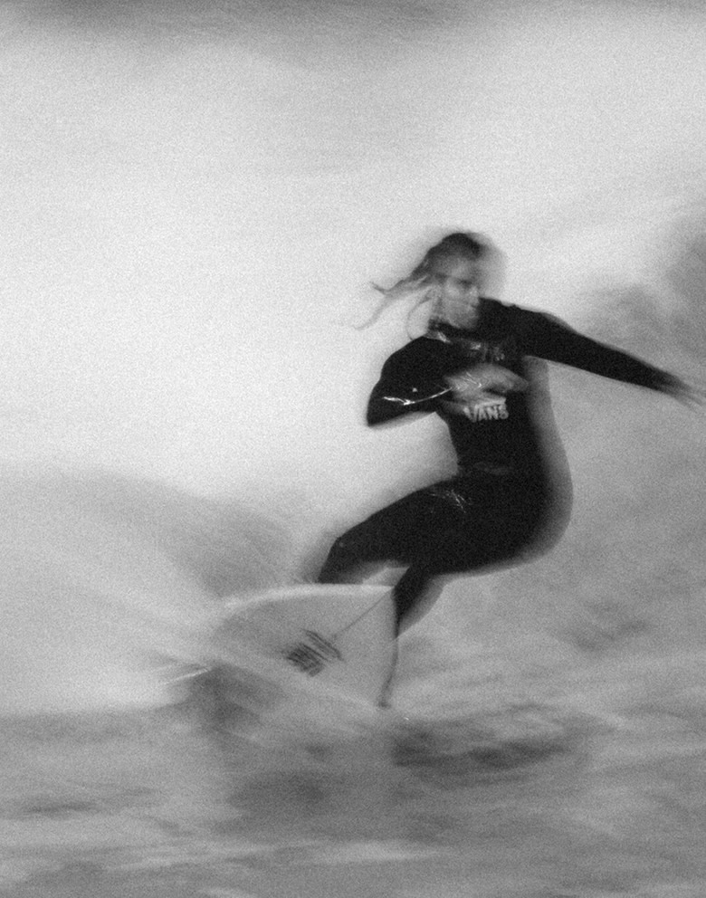 A Vans athlete and professional surfer rides a wave inside a barrel towards the camera.