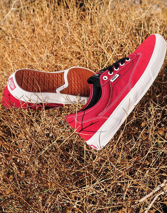 A pair of red Curren shoes tossed into tall dead grass for an effortless and natural atmosphere.
