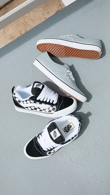 An overhead shot of Pure Grey Authentic shoes and Checkerboard Knu Skool shoes on the pavement.