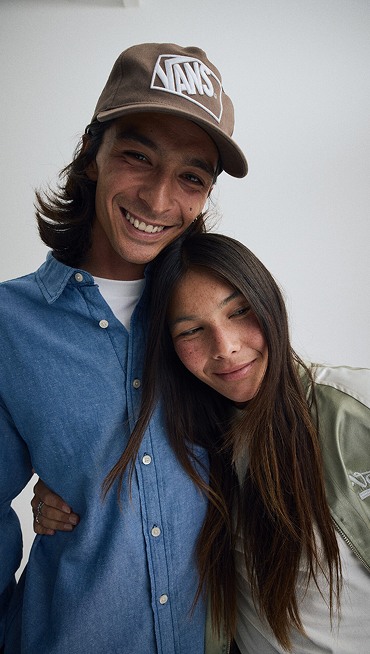 Close-up of a young man and woman embracing each other wearing new Vans clothes.