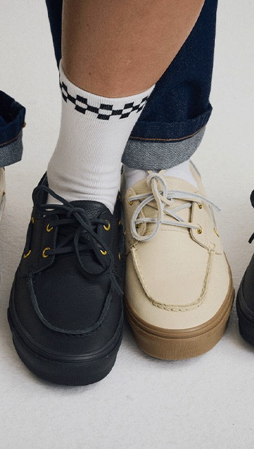 Close-up on two people wearing the black colorway and the cream colorway of the 2-Eyelet Boat Shoe.