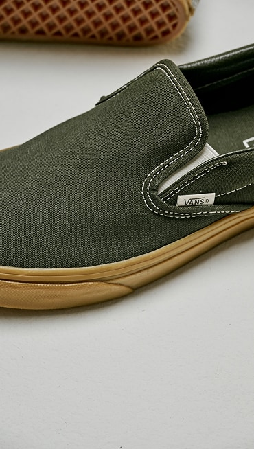 Close up of the Classic Slip-On Shoe in Gum Obsidian Fern Green sitting on the floor of a grey photography studio.