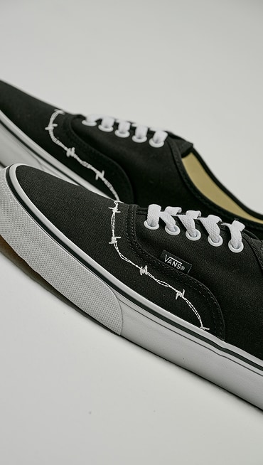 Close up shot of a pair of Authentic Shoe in Black / White with a barbed wire design embroidered on the toebox.