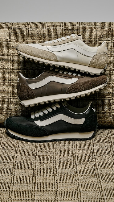 All three white, black, and brown colorways of the Premium Style 152 stacked on top of each other on a sofa.