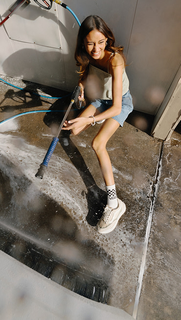 Vans Surf Team Rider Maddie Miller wearing the creme beige UltraRange 2.0 at a car wash.