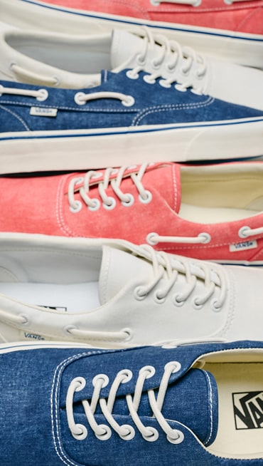 The three white, salmon, and blue colorways of the Authentic Boat Shoe laid out on a floor together.