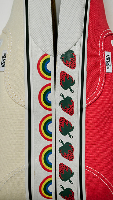 Close-up on the archival sidewall rainbow graphics on the marshmallow white Authentic and the strawberry graphics on the crimson haze red Authentic.