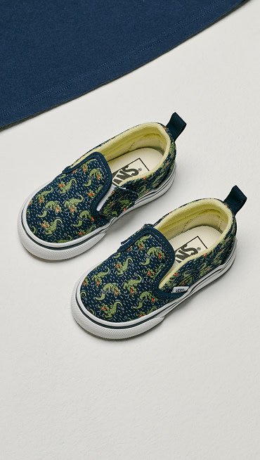 An overhead shot of glow-in-the-dark navy crocodile print Toddler Classic Slip-On V shoes.