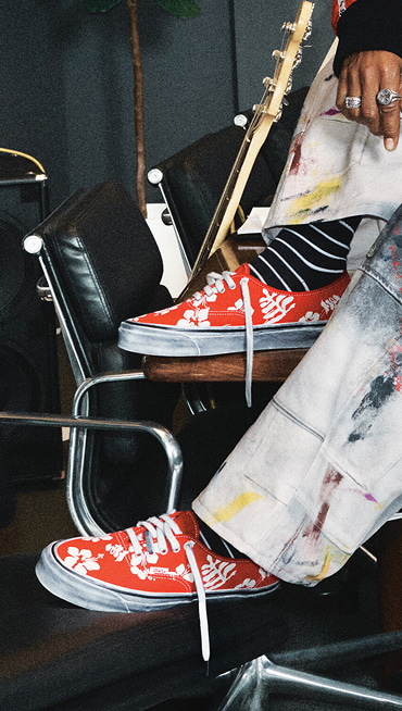 A knee-down shot of someone wearing red floral Premium Authentic shoes from the Worn Loud Authentic Legacy drop.