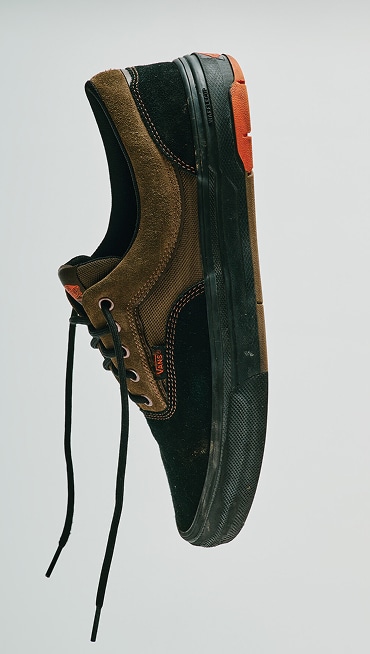 A pair of brown and black Skate Era WaffleCup shoes in a photography studio, one balanced on its toe and the other on its heel.