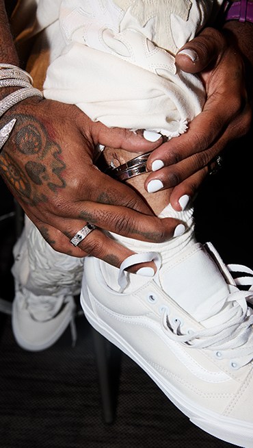 SP25_PLP_LowtopShoes_eSpot1x1-01_06122025_Desktop_458x673_Image A close-up of Lil Uzi Vert holding his silver anklet and sock over his white Old Skool shoes.