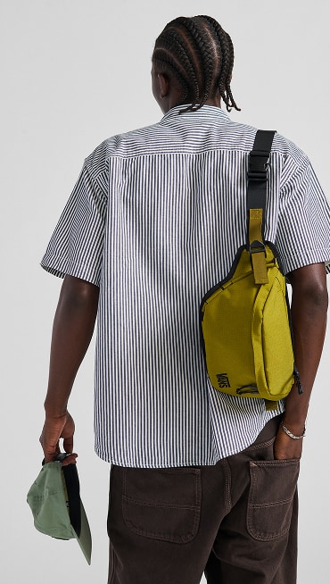 A close up of the back of a man wearing vans green bag