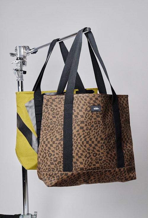A Dachshund Brown handbag hanging on a rack in a photography studio.