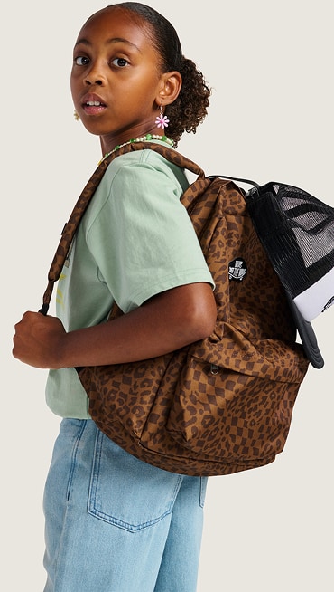 A young girl looks over her shoulder wearing a Dachsund Brown Old Skool Classic Backpack.