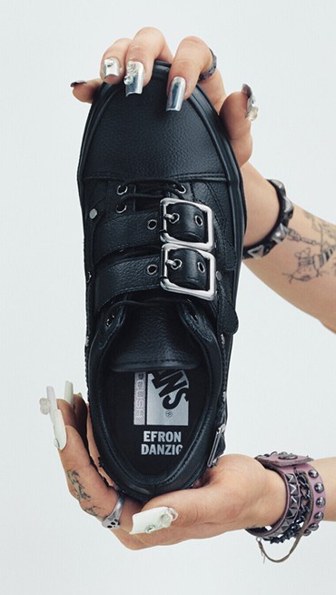 Vans Skate Team Rider Efron Danzig holds up her Premium Old Skool in a photography studio with her name on the interior sole.