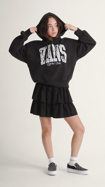 A woman twirls in a denim overshirt and skirt wearing white Authentic in a photography studio.